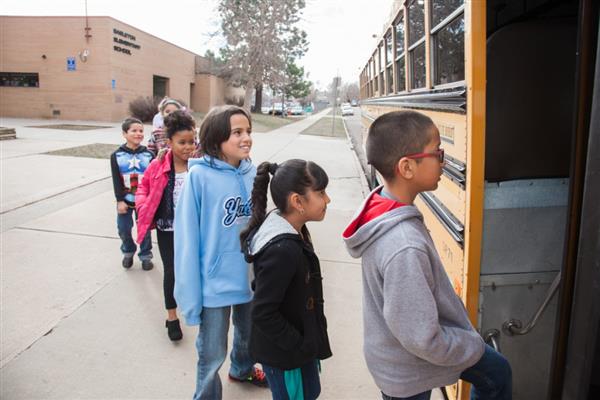 Children line up to board the school bus